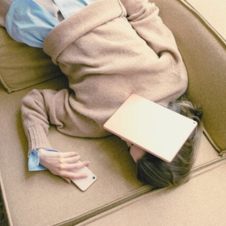 Woman laying down with book covering her face — stress support with Natalie Hall.