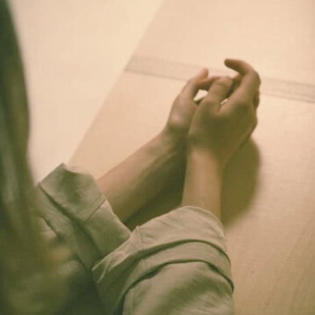 Woman sitting with hands out in front, contmeplating — stress support with Natalie Hall.
